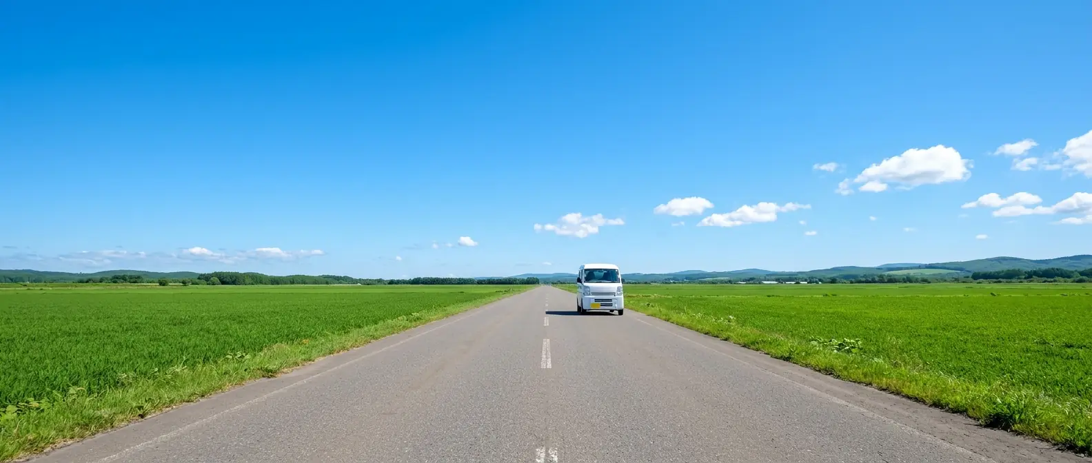 夕暮れの道を走る配送車